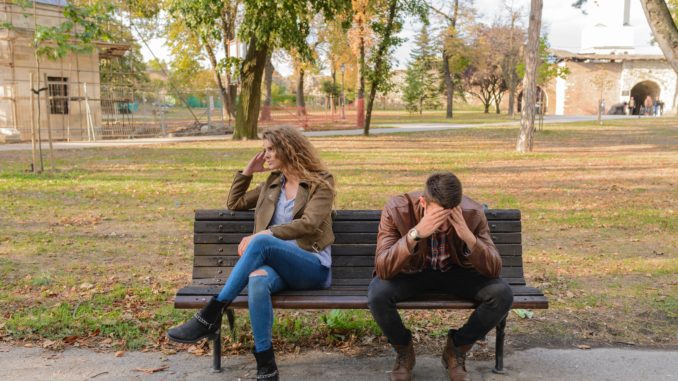 woman-and-man-sitting-on-brown-wooden-bench-984949