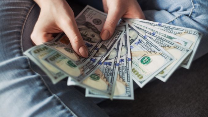 person-holding-100-us-dollar-banknotes-2068975